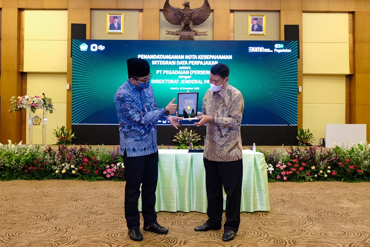 Dirjen Pajak Suryo Utomo dan Direktur Utama PT Pegadaian (Persero) Kuswiyoto bertukar cendera mata