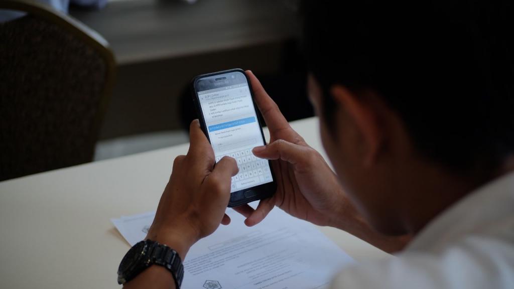 Salah satu karyawan tengah serius mengisi SPT Tahunan melalui handphone