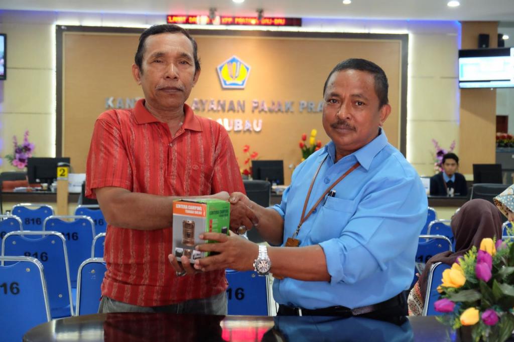 Perwakilan KPP Pratama Baubau Menyerahkan Hadiah Kepada Wajib Pajak