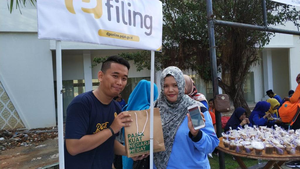 Petugas Pojok Pajak KP2KP Baradatu memberikan bingkisan kepada Wajib Pajak yang dapat menunjukkan tanda terima pelaporan SPT Tahunan PPh.