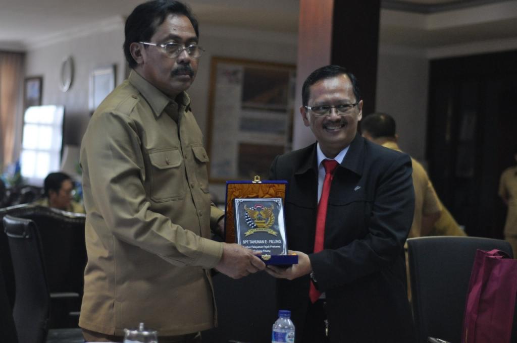 Kepala KPP Tanjungpinang Dadang Karna Permana memberikan plakat ucapan terima kasih kepada gubernur karena telah melaporkan SPT Tahunan dengan e-filing