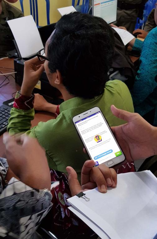 Petugas memberikan contoh pengisian efilling menggunakan smartphone