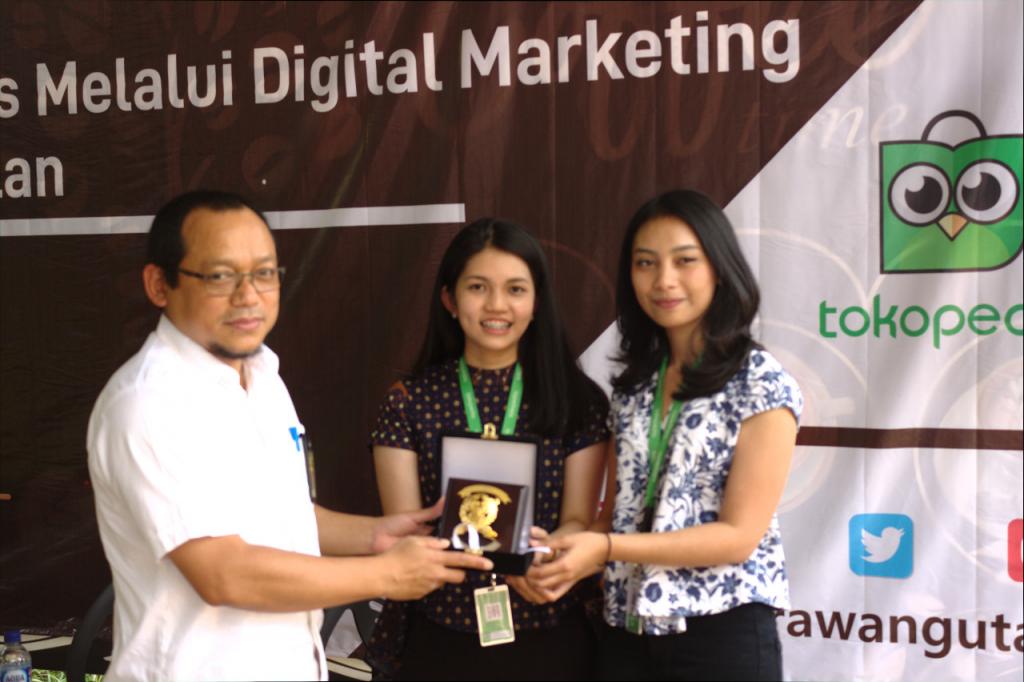 Pemberian plakat kepada narasumber dari Tokopedia
