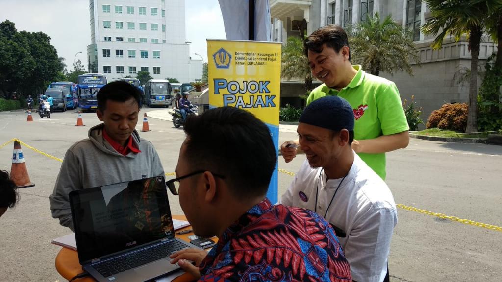 Petugas melayani Wajib Pajak yang hendak melakukan cetak ulang kartu NPWP