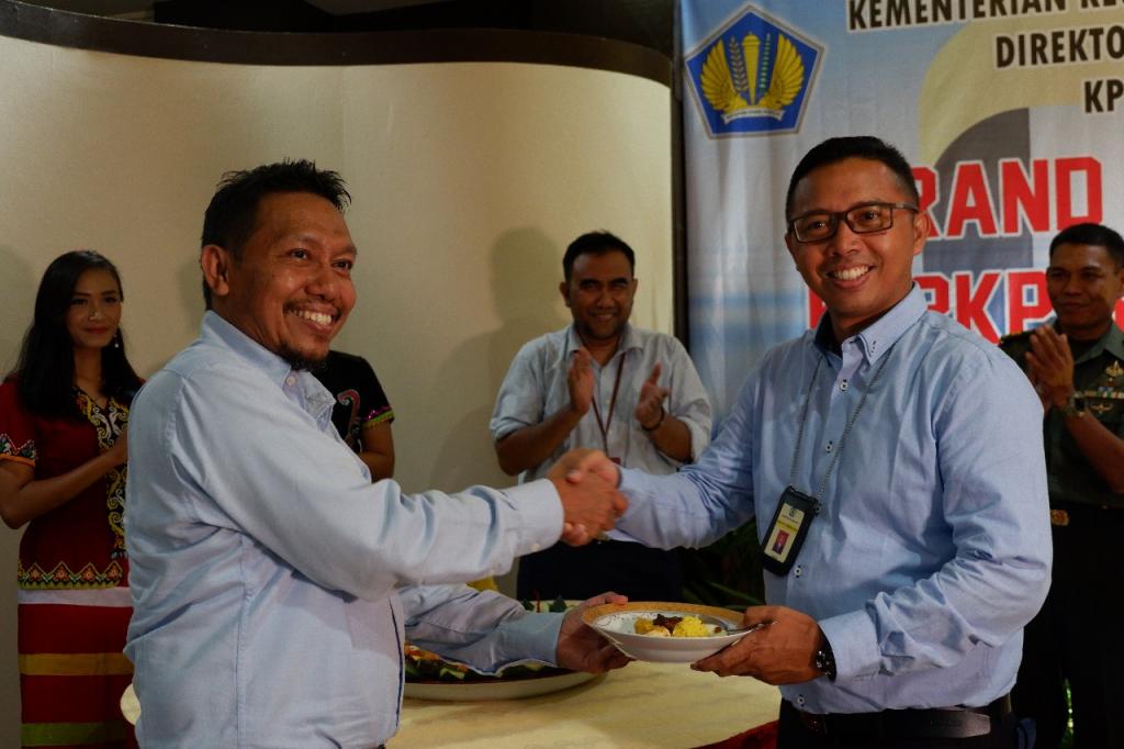 Kakanwil DJP Kaltimra Samon Jaya menyerahkan tumpeng kepada Kepala KP2KP Sendawar Sofwan