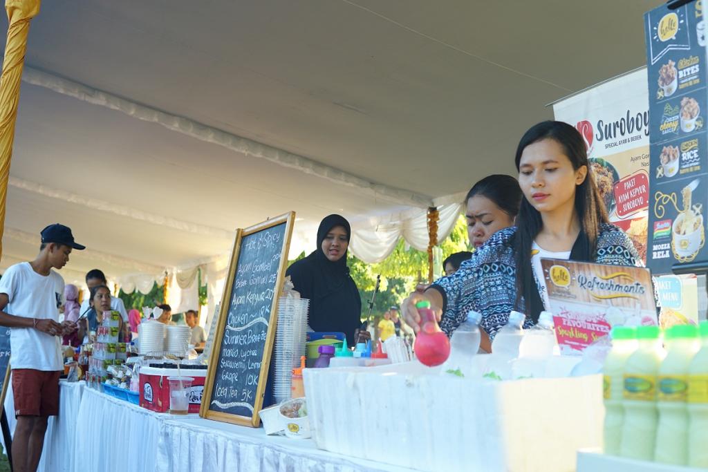 tampak seorang peserta bazar UMKM yang diundang panitia sedang melayani pengunjung, di akhir acara setiap peserta bazar diwajibkan memiliki NPWP dan menyetor kewajiban perpajakannya sebesar 1% dari omzet jualan mereka hari ini